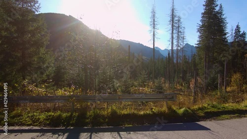 View on Zakopane polish mountains during walk to Morskie Oko during autumn sunny day with beautiful sun behind mountains.