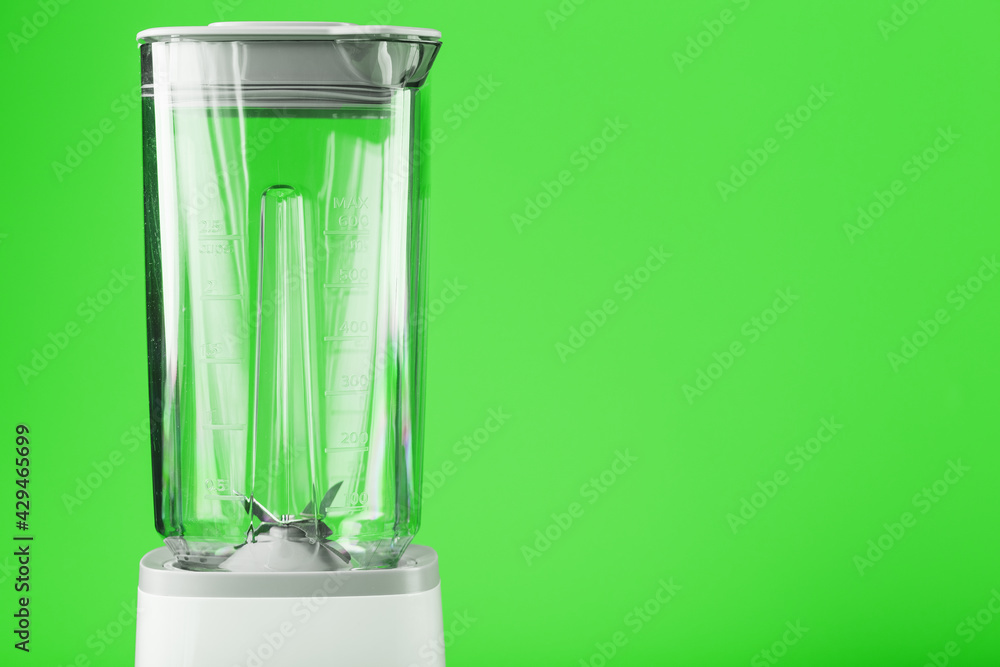 Electric blender with an empty jug on a green background. Electric blender with an empty jug on a green background.