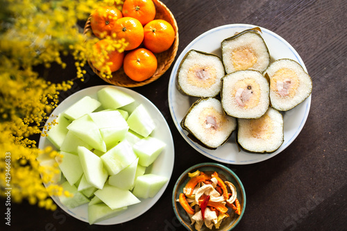Vietnamese food (Tet cake) and cut prepared fruit on plate on Tet holiday