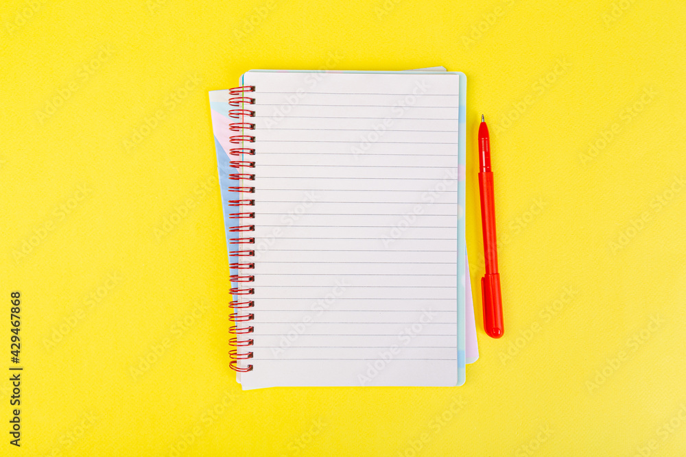 open spiral notepad on a yellow background with a pen. top view, stack of notepad with blank sheet. school concept, businessman work open spiral notepad on a yellow background with a pen. top view, stack of notepad with blank sheet. school concept, businessman work