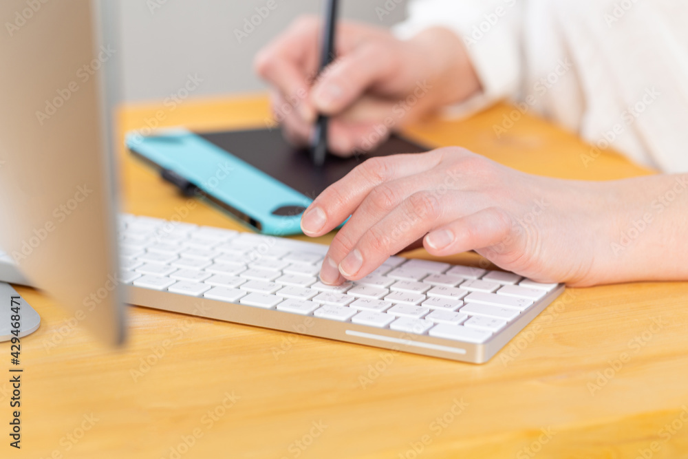 A graphic designer works on a digital tablet. work from home A graphic designer works on a digital tablet. work from home