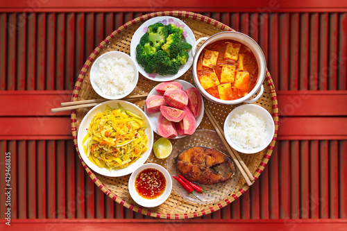 Vietnamese style family lunch set for two persons on red vintage table background