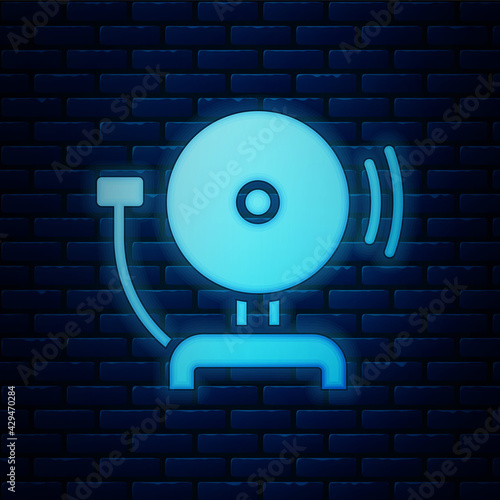 Glowing neon Ringing alarm bell icon isolated on brick wall background. Fire alarm system. Service bell, handbell sign, notification symbol. Vector