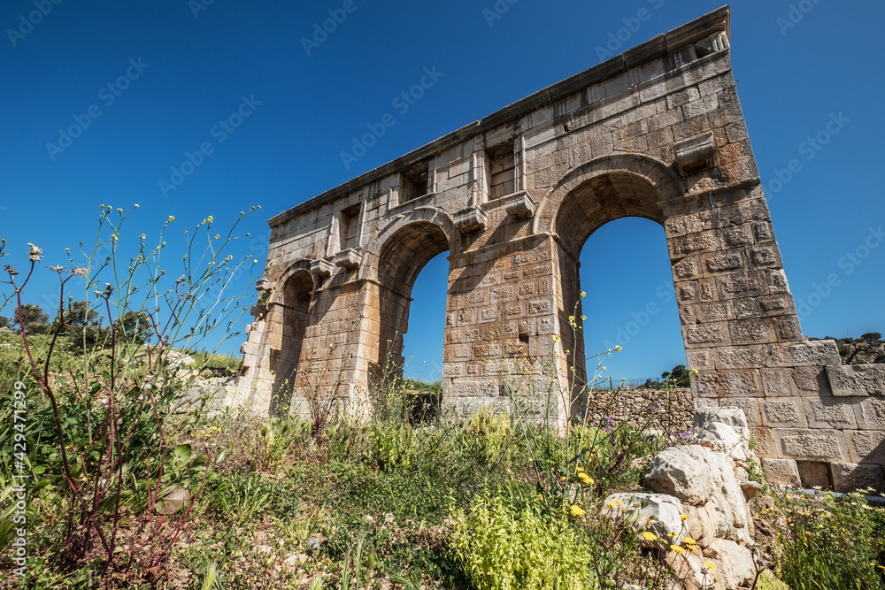 The symbol of ancient Patara (Lycia) city - Arch of Mettius Modestus, Mediterranean coast of Turkey. Architecture Art and traveling around the world concept image.