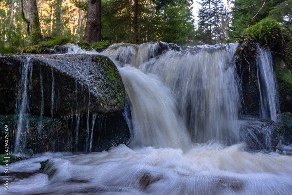 Fototapeta premium Cascade falls over mossy rocks
