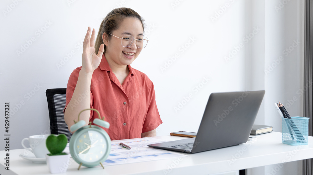 Young Asian women are greeting friends and teachers through video chats and greeting them with cheerful expressions, Online communication , Stay home, New normal, Covid-19 coronavirus. Young Asian women are greeting friends and teachers through video chats and greeting them with cheerful expressions, Online communication , Stay home, New normal, Covid-19 coronavirus.
