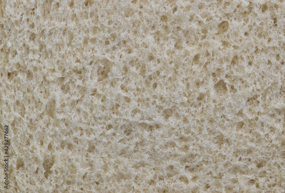 White bread texture, closeup slice with macro surface details. One of mankind's oldest staple foods.