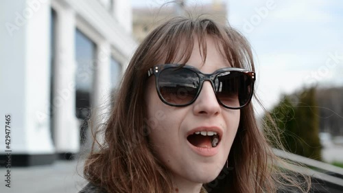 Portrait of a beautiful young brown-haired girl who chews chewing gum