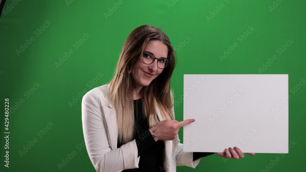 Young pretty woman holds a dummy sign and points to it - studio photography Young pretty woman holds a dummy sign and points to it - studio photography