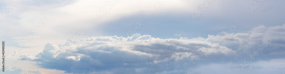Obraz premium Panorama of a cloudy sky with clouds arranged in a row