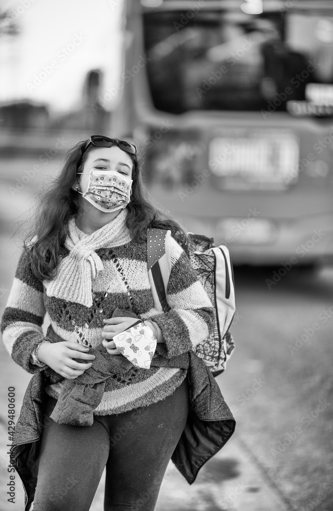 Young girl at the bus stop wearing mask in covid pandemic Young girl at the bus stop wearing mask in covid pandemic