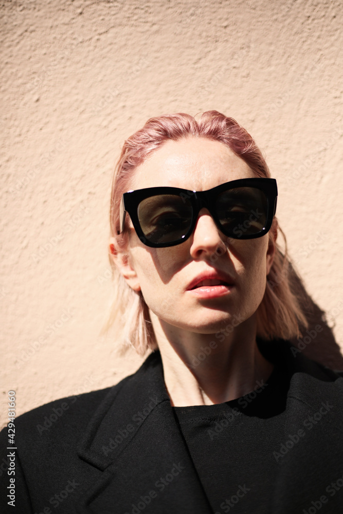Vertical portrait of young woman with pinkish hair, wearing sunglasses. Vertical portrait of young woman with pinkish hair, wearing sunglasses.