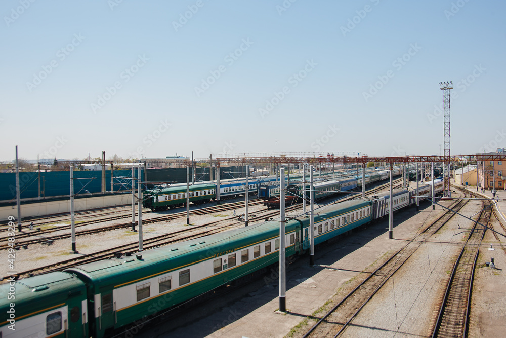 Parking for diesel electric locomotive. Vintage green train cars at the station.