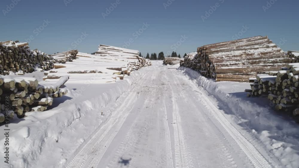 a view from a flying drone over a log warehouse at a woodworking factory in winter a view from a flying drone over a log warehouse at a woodworking factory in winter