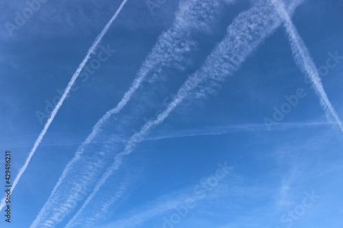 Blue sky with plane trails. Traces of planes and clouds.