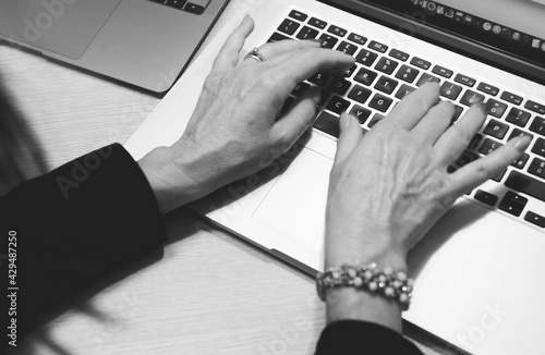 фотографія Woman hand working on a notebook using touchpad and keyboard, close up