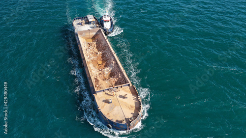 Aerial drone photo of assisted with tug boat barge filled with stones near Mediterranean port © aerial-drone