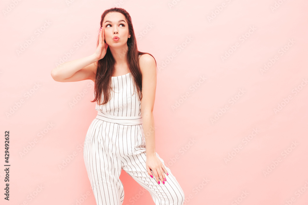 Portrait of young beautiful smiling female in trendy summer hipster clothes. Sexy carefree woman posing near pink wall in studio. Positive model having fun indoors. Cheerful and happy Portrait of young beautiful smiling female in trendy summer hipster clothes. Sexy carefree woman posing near pink wall in studio. Positive model having fun indoors. Cheerful and happy