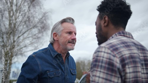 Senior Male Driver Arguing Over Blame For Car Accident With A Younger Male Motorist