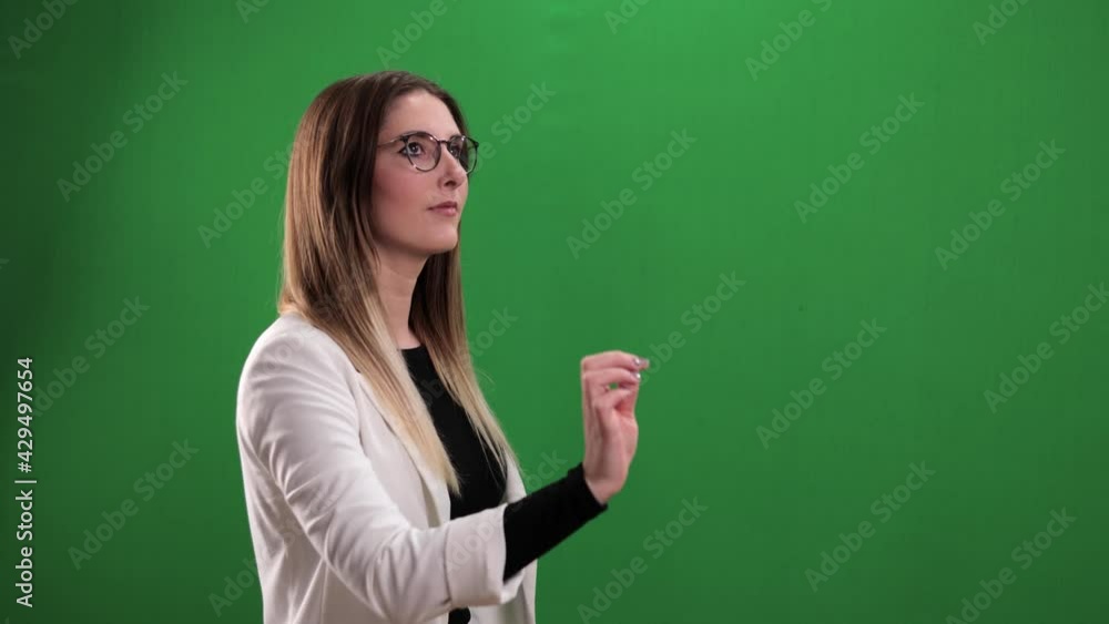Young woman taps on a large imaginary touchscreen - studio photography Young woman taps on a large imaginary touchscreen - studio photography