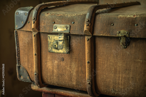 An old brown travel suitcase with wooden inserts and a brass lock