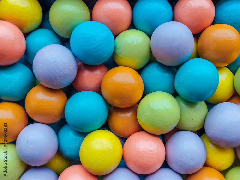 Background from multicolored bright small wooden balls of blue, yellow, red, lilac and green colors. A beautiful summer bright background for your projects.. Background from multicolored bright small wooden balls of blue, yellow, red, lilac and green colors. A beautiful summer bright background for your projects..