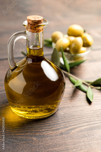 Extra virgin olive oil in a bottle, green olives and olive tree branches. healthy eating concept, basic products of the Mediterranean diet.