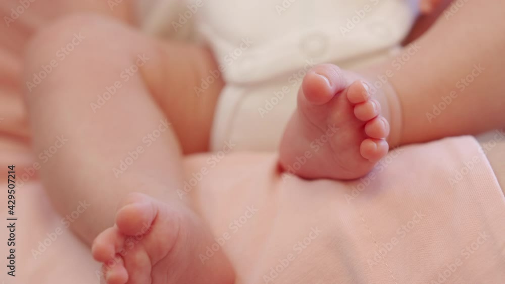 Tiny feet of newborn baby boy closeup 1.5 month old infant lying on mother lap while breastfeeding. High quality 4k footage Tiny feet of newborn baby boy closeup 1.5 month old infant lying on mother lap while breastfeeding. High quality 4k footage