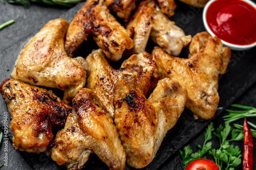 grilled chicken wings with spices on a stone background