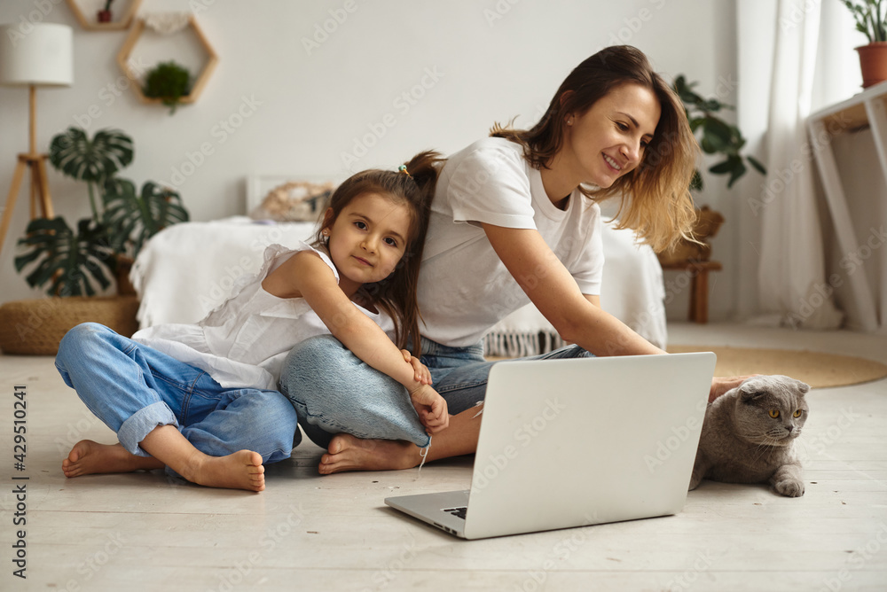 daughter watching mom work on computer daughter watching mom work on computer