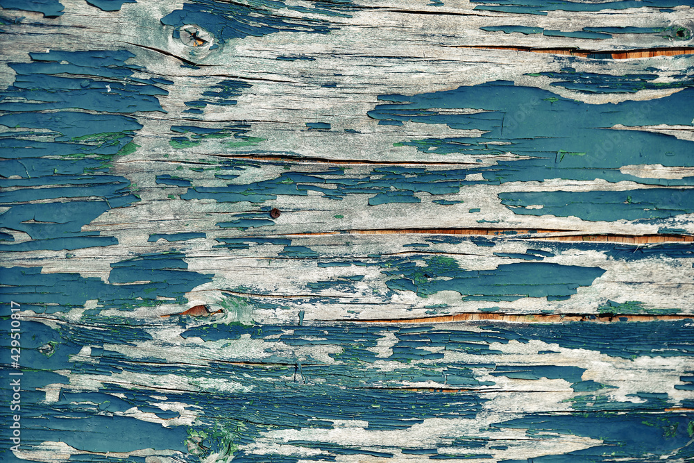 The texture of the painted peeling paint of the plywood wall. Aging and unsuitability of the material