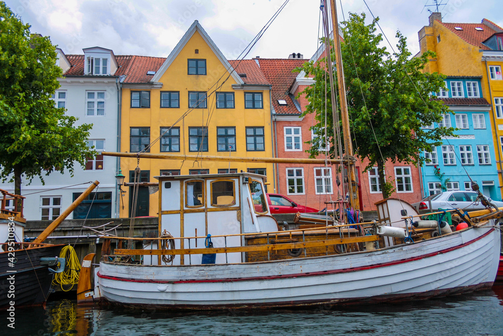 Old wooden barge along a canal in Copenhagen, in the background historic buildings
