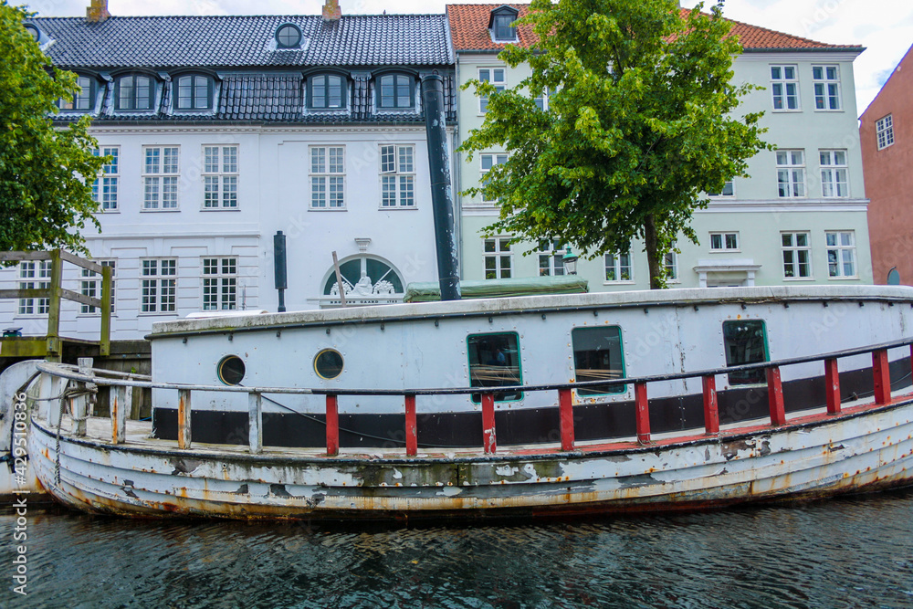 Old wooden barge along a canal in Copenhagen, in the background historic buildings