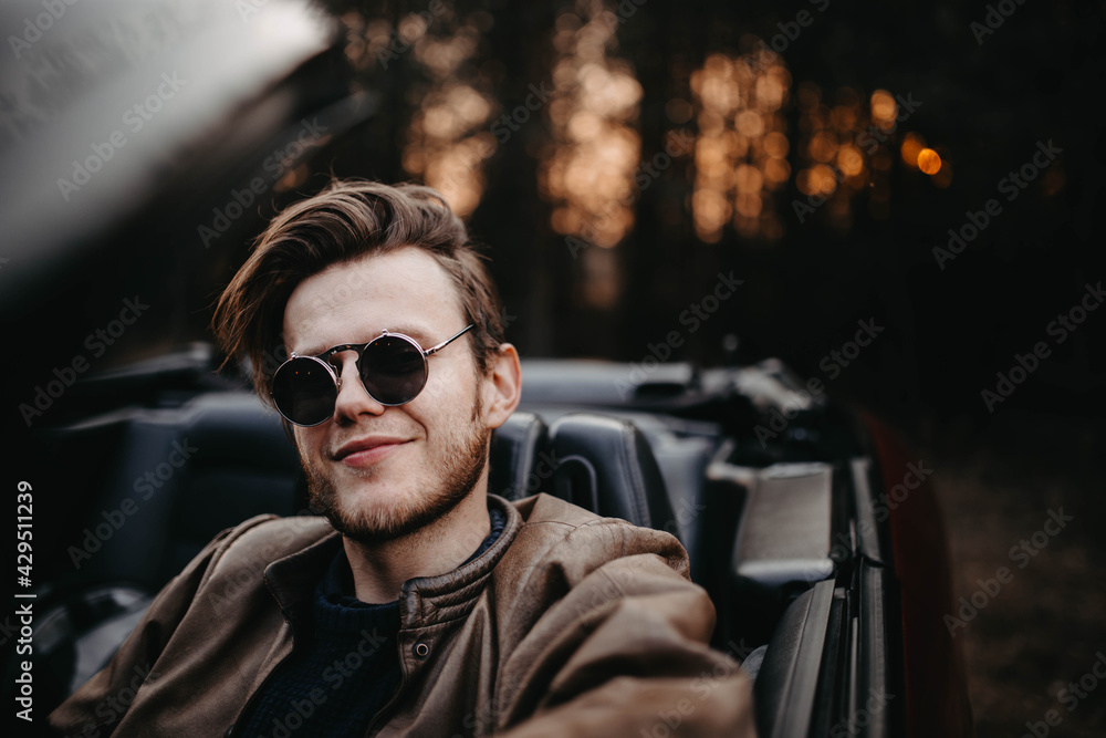 fashionable man in sunglasses in a convertible, pretentious driver. fashionable man in sunglasses in a convertible, pretentious driver.