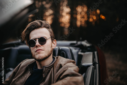 fashionable man in sunglasses in a convertible, pretentious driver. © velimir