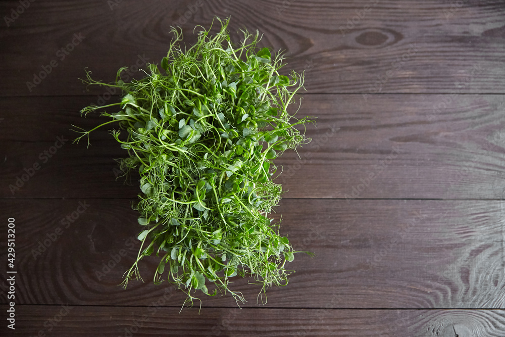 Pea microgreens on wooden table. Micro greens pea sprouts with fresh leaves Pea microgreens on wooden table. Micro greens pea sprouts with fresh leaves