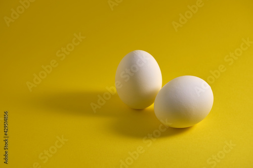 Chicken eggs and eggshells on a yellow background.