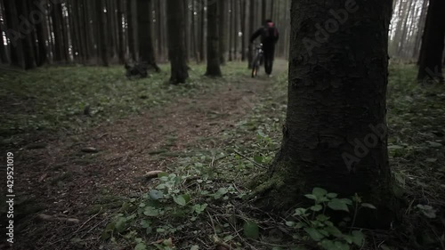 The guy in the woods with a bike.