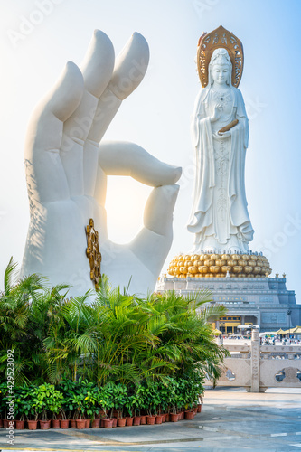 Canvas Print Vertical view of white hand statue with Dharma wheel and Guanyin of the South Se