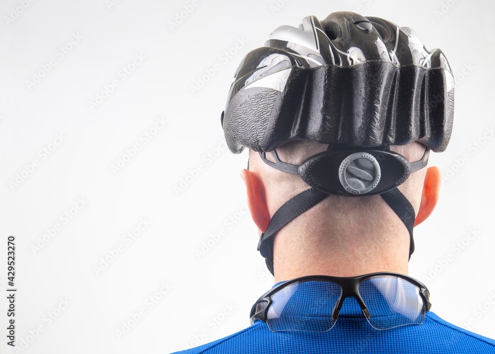 Naklejka premium Male cyclist in a bicycle helmet from the back on a light background