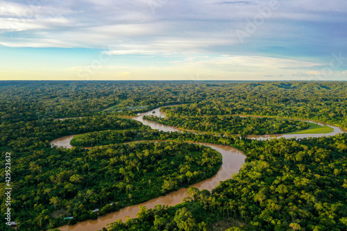 Fotografia Aerial view over a tropical forest with a river meandering through the canopy an