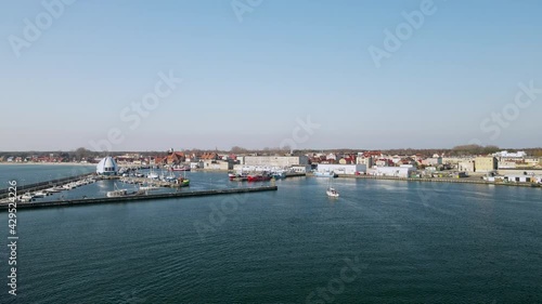 Wallpaper Mural Hel Peninsula before the season, a white sailboat enters the harbor on the calm water of the Puck Bay, slow motion aerial, Poland Torontodigital.ca