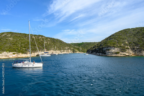 Panoramic view of the bay with mountains against blue sky with clouds. White yacht in the foreground. Horizontal view © Vitaliy