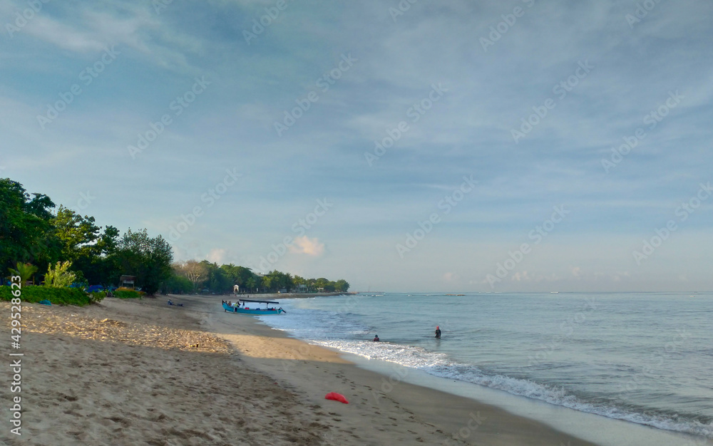 Obraz premium A woman walking around Kuta Beach Bali and playing with the doga.