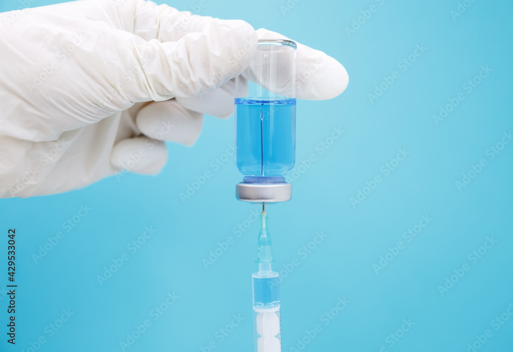 Vaccination against the new coronavirus. Influenza flu vaccine vials with syringe. Immunity against diseases. Medical syringe with blue liquid. Vaccine, immunity system to protect from virus infection Vaccination against the new coronavirus. Influenza flu vaccine vials with syringe. Immunity against diseases. Medical syringe with blue liquid. Vaccine, immunity system to protect from virus infection