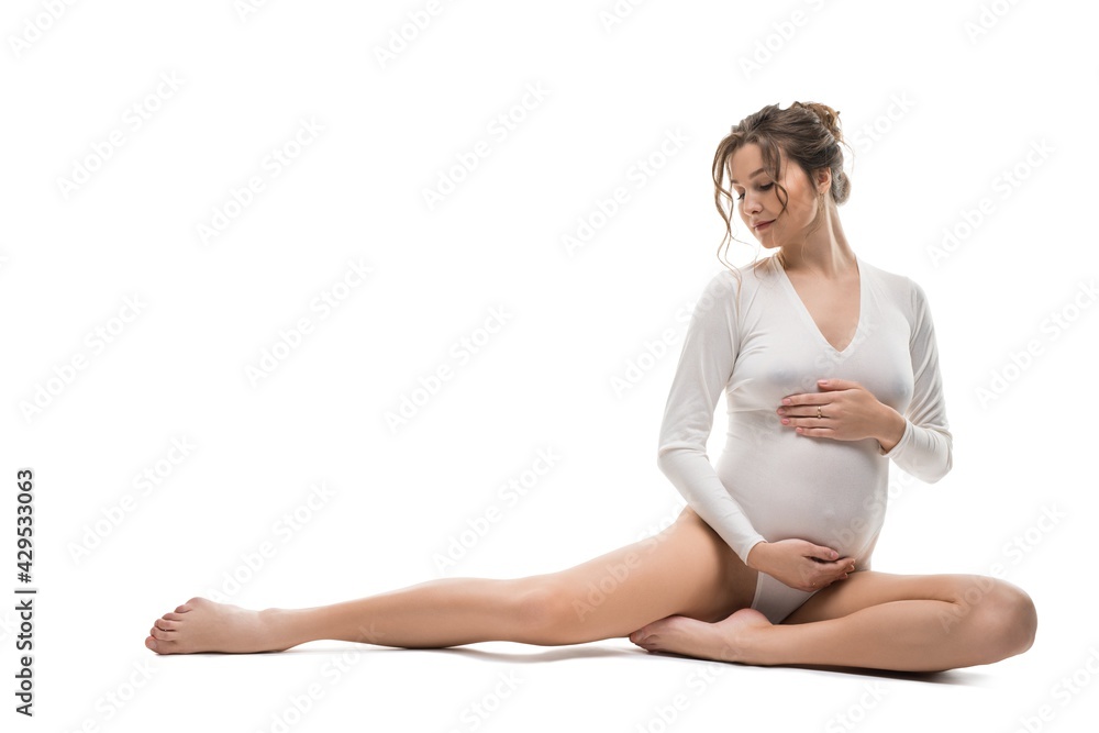 Graceful pregnant woman in white bodysuit relax on background Graceful pregnant woman in white bodysuit relax on background