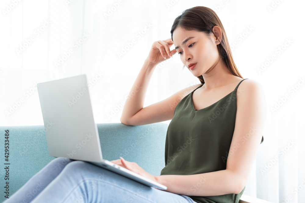Asian woman is using laptop with worried expression Asian woman is using laptop with worried expression