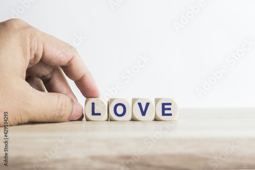 A word "Love" on a wooden table over the light background.