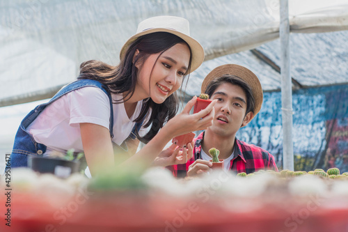 young smart farmer,keeping growth cactus in potted in greenhouse park,concept agriculture hobbies at plant nursery time and happy,small business selective focus women