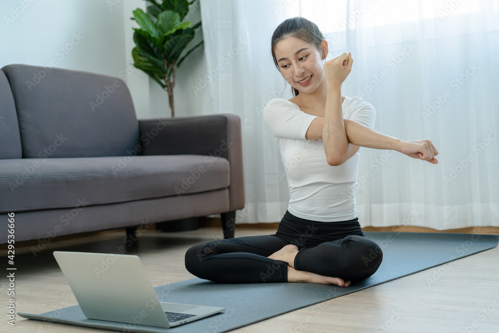 Fit, sporty asian young beautiful woman, girl sitting physical or pilates, watching trainer online on laptop computer, training in living room.Workout fitness exercise people in sportswear at home. Fit, sporty asian young beautiful woman, girl sitting physical or pilates, watching trainer online on laptop computer, training in living room.Workout fitness exercise people in sportswear at home.
